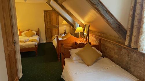 a bedroom with two beds in a room with a attic at Crown Hotel in Downham Market