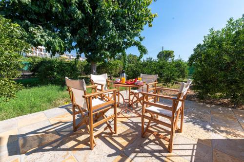a wooden table with chairs and a table with fruit on it at Anesis Residence in Dhrepanon