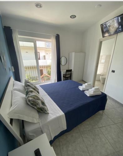 a bedroom with a bed with a blue blanket and a window at AMARIS in Tortolì