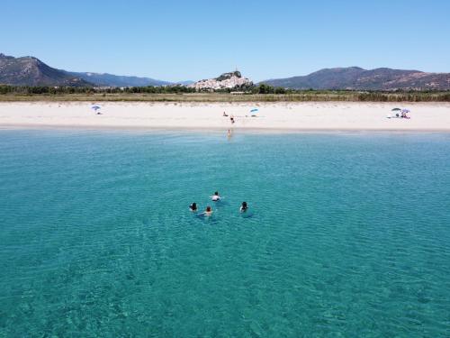 a group of people swimming in the water at a beach at Casa Angelina-Ammentos Posada in Posada