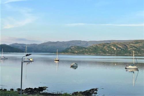 a group of boats sitting on a large body of water at Kames View Apartment in Tighnabruaich