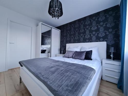 a bedroom with a large bed and a mirror at Apartament Nad wierzbami in Piechowice
