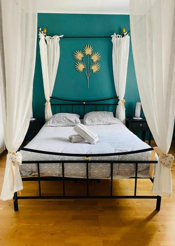 a bed in a room with a green wall at Au pied de la Cathédrale in Colmar
