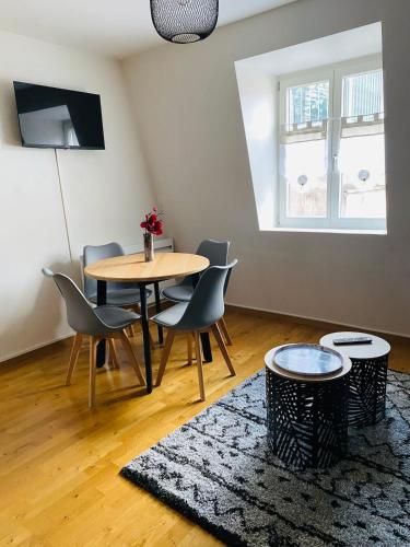 une salle à manger avec une table, des chaises et un tapis dans l'établissement Au pied de la Cathédrale, à Colmar