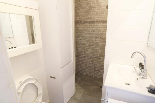 Un baño blanco con inodoro y lavabo. en כוכב הים וילה מול הגלים וברכה פרטית סגורה, en Netanya