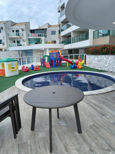 a playground with a table and a small pool at Apê da Fla in Arraial do Cabo