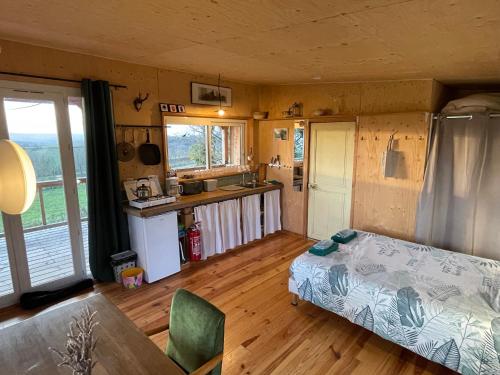une chambre avec un lit et une cuisine avec une table dans l'établissement Chalet panoramique et moderne tout confort, à Saizy