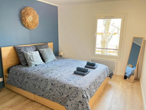 una camera da letto con un letto con pareti blu e una finestra di Le Briand ad Aix en Provence