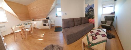a living room with a couch and a table at Apartament Grel in Nowy Targ