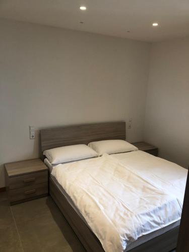 a bedroom with a large bed and two night stands at CASA COSTA AL SOLE in Lazise