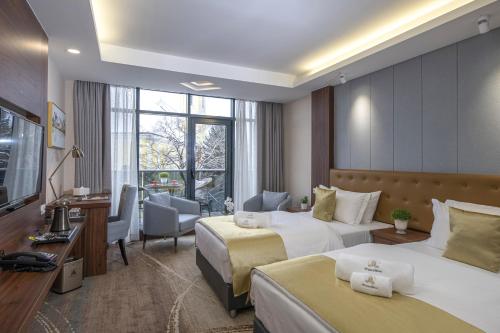 a hotel room with two beds and a television at Willis Hotel Business & Wellness in Zalaegerszeg