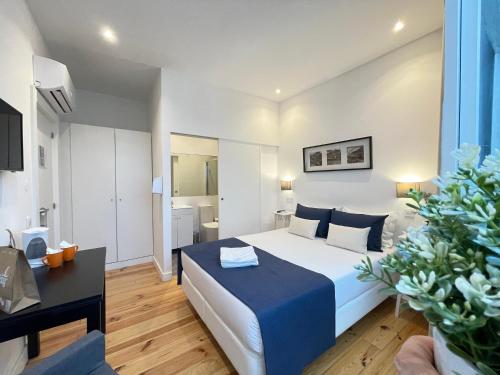 a bedroom with a large white bed and a desk at MyStay Porto Centro in Porto