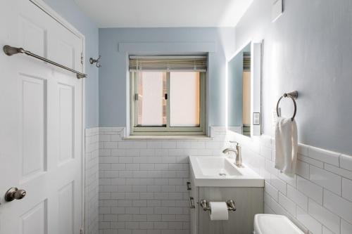 ein weißes Badezimmer mit Waschbecken und Spiegel in der Unterkunft Rare 2 Bed 2 Bath Downtown Condo Near Aquarium in Atlanta