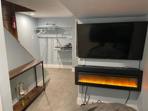 a living room with a tv and a fire place at Downtown Suite - Close to Topgolf, Horseshoe Casino, UM Baltimore in Baltimore