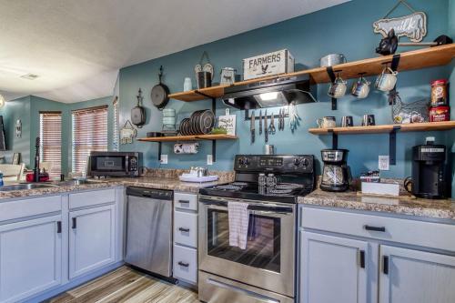 a kitchen with a stove and a blue wall at The Mason Jar, Hot Tub, WIFI, 560 FREE tickets each paid day in Pigeon Forge