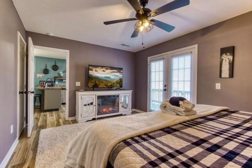 a bedroom with a bed with a fireplace and a ceiling fan at The Mason Jar, Hot Tub, WIFI, 560 FREE tickets each paid day in Pigeon Forge