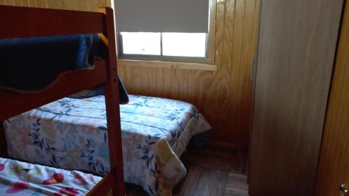 a bedroom with a bunk bed and a window at Cabañas curacautin in Curacautín