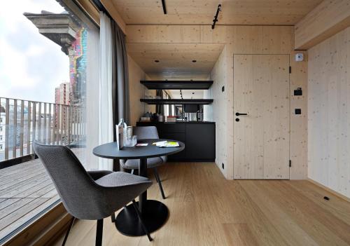 a small dining room with a table and a large window at numa l Wood Rooms & Apartments in Vienna