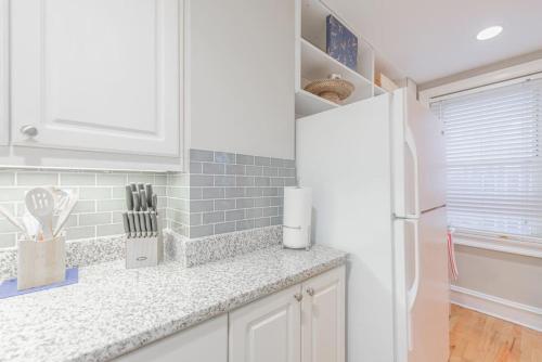 a kitchen with white cabinets and a white refrigerator at Stayatl Downtown Atlanta Condo In Hotel District in Atlanta