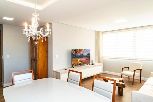 uma sala de jantar com uma mesa branca e cadeiras em Apartamento moderno no Vale dos Vinhedos em Monte Belo