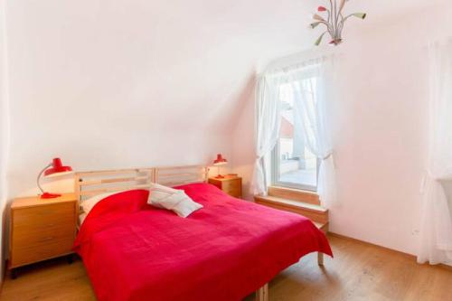 a bedroom with a red bed and a window at Gästesuiten beim Schloss in Eisenstadt