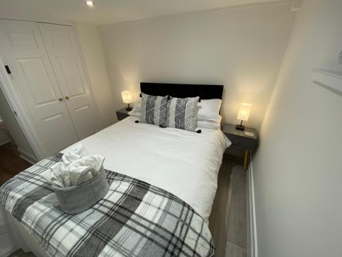a bedroom with a white bed with a basket on it at Westons Hideaway, 2 Bed, Free Parking, 6 mins walk to beach, in Weston-super-Mare