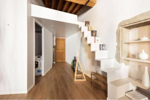 - un escalier dans une chambre dotée de murs blancs et de parquet dans l'établissement Au coeur de la vieille ville, à Annecy