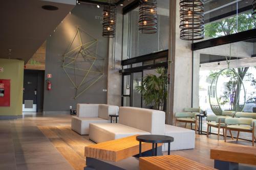 a lobby with couches and tables in a building at ibis Styles Porto Alegre Moinhos de Vento in Porto Alegre