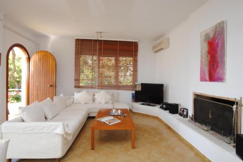 a living room with a white couch and a table at Stavento Apartments in Argostoli
