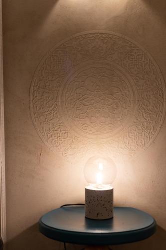 a candle on a table in front of a wall at Caveau in Palermo
