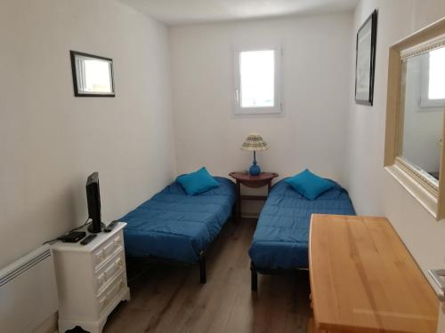 a living room with two beds and a table at Appartement 2 pièces pour 4 personnes avec vue mer in Saint-Hilaire-de-Riez