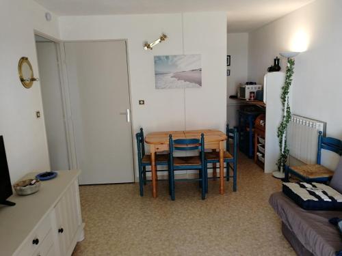 uma sala de jantar com uma mesa e cadeiras num quarto em Appartement 2 pièces pour 4 personnes avec vue mer em Saint-Hilaire-de-Riez