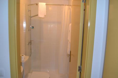 a bathroom with a shower and a toilet at Hotel Comércio in Resende