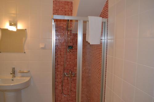 a bathroom with a shower with a sink and a toilet at Hotel Comércio in Resende