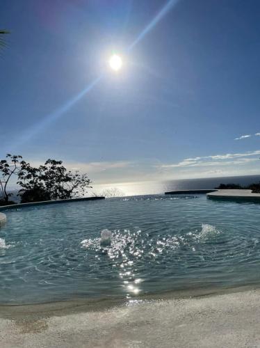 a body of water with the sun in the sky at Casitas Sollevante Boutique Hotel in Montezuma