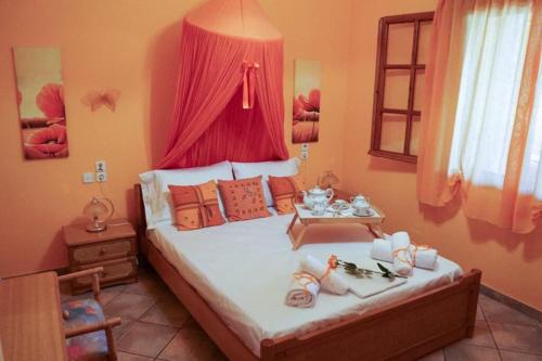 - une chambre avec un grand lit et des rideaux rouges dans l'établissement VILLA DREAM, à Skiathos Chora