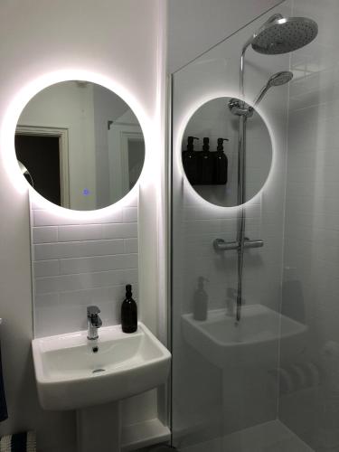 a bathroom with a sink and a shower and a mirror at Central Falmouth with parking & courtyard in Falmouth