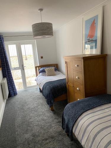 a bedroom with two twin beds and a dresser at Central Falmouth with parking & courtyard in Falmouth