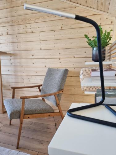 a chair and a lamp in a room at Drewniany dom w brzozowisku in Pieszyce