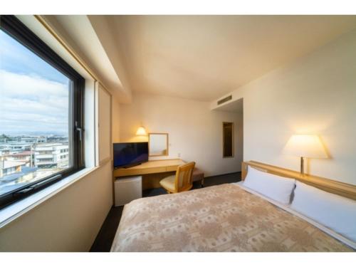 a bedroom with a bed and a desk and a window at Green Hotel Omagari - Vacation STAY 19287v in Daisen
