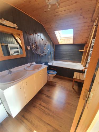Chalet 8-10 personnes Auris en Oisans Domaine de l'Alpe d'Huez في أوري: حمام مع مغسلتين وحوض استحمام
