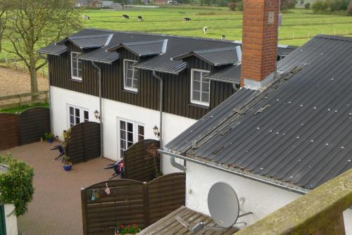 ein Haus mit Sonnenkollektoren darüber in der Unterkunft Ferienwohnungen Engelmühle in Nordstrand