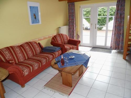 ein Wohnzimmer mit einem Sofa und einem Couchtisch in der Unterkunft Ferienwohnungen Engelmühle in Nordstrand