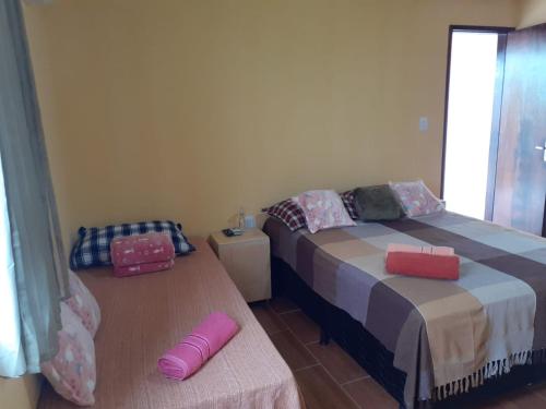 a bedroom with a bed and a table with two pink pillows at Recanto Novo Horizonte in Recife