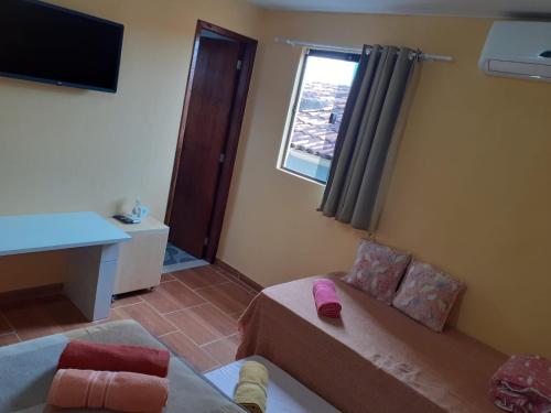 ein Wohnzimmer mit einem Sofa und einem Fenster in der Unterkunft Recanto Novo Horizonte in Recife