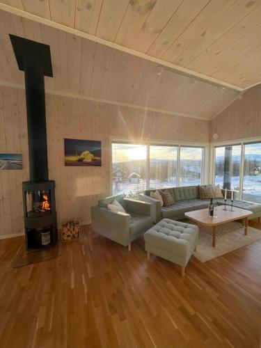 a living room with a couch and a fireplace at Skarvebo - cabin with amazing view in Myro