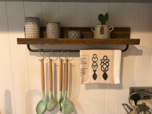a kitchen rack with cooking utensils on a wall at Wyncliffe Hideaway in St. Davids
