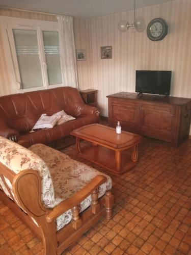 uma sala de estar com um sofá e uma mesa em Maison de vacances em Granges-sur-Vologne
