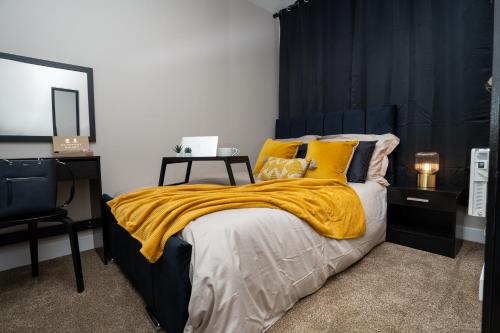1 dormitorio con 1 cama con manta amarilla en JPG Tower Suite - 22nd Floor Canal & City Views, en Mánchester
