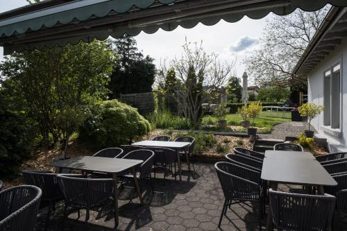 a patio with tables and chairs in a garden at Gasthaus Hotel Kranz in Laufenburg